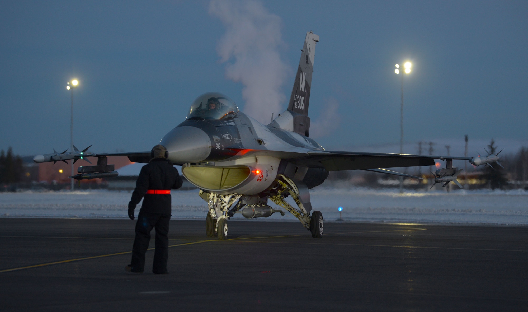 A U.S. Air Force Airman assigned to the 354th Maintenance Group inspects a U.S. Air Force F-16 Fighting Falcon intake for ice build up prior to launch for an elephant walk on Eielson Air Force Base, Alaska, Dec. 18, 2020.