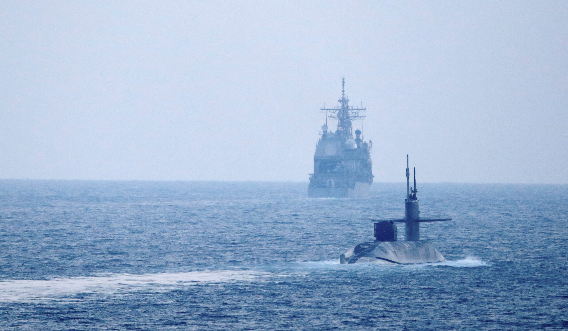 The guided-missile submarine USS Georgia (SSGN 729), front, transits the Strait of Hormuz with the guided-missile cruiser USS Port Royal (CG 73) and the guided-missile cruiser USS Philippine Sea (CG 58), not pictured, Dec. 21. Georgia is deployed to the U.S. 5th Fleet area of operations in support of naval operations to ensure maritime stability and security in the Central Region, connecting the Mediterranean and Pacific through the Western Indian Ocean and three critical chokepoints to the free flow of global commerce.
