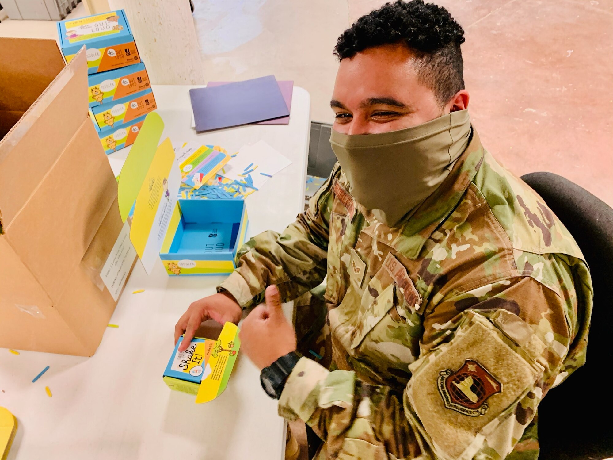 Senior Airman Kwame Robertson of Wright-Patterson Air Force Base’s National Air and Space Intelligence Center builds “Love Them Out Loud” kits during the Dec. 18 volunteer event benefiting the Dayton Metro Library and early childhood literacy.