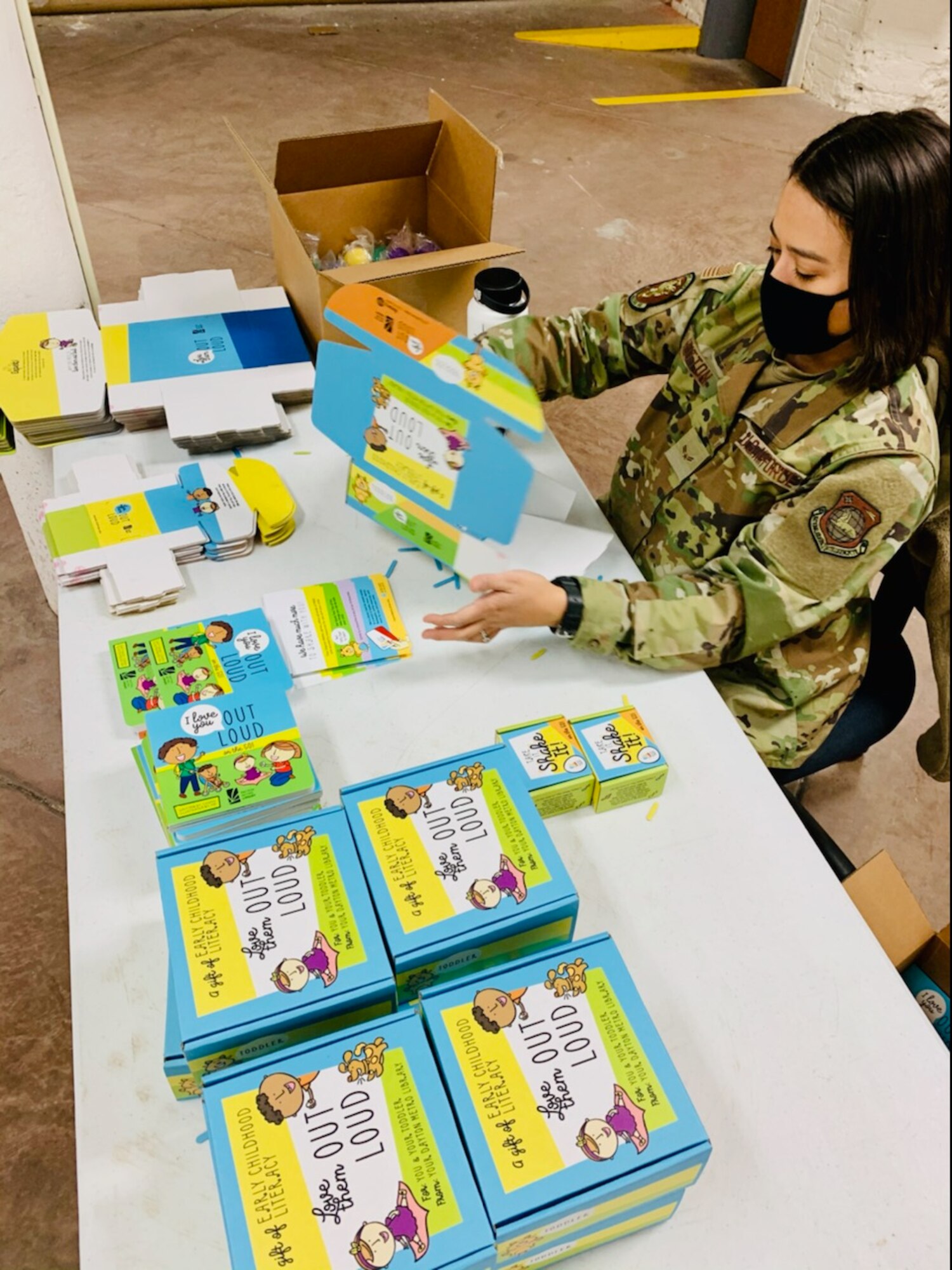 Airman 1st Class Miranda Hutton of Wright-Patterson Air Force Base’s National Air and Space Intelligence Center puts together “Love Them Out Loud” kits during the Dec. 18 volunteer event benefiting the Dayton Metro Library and early childhood literacy.
