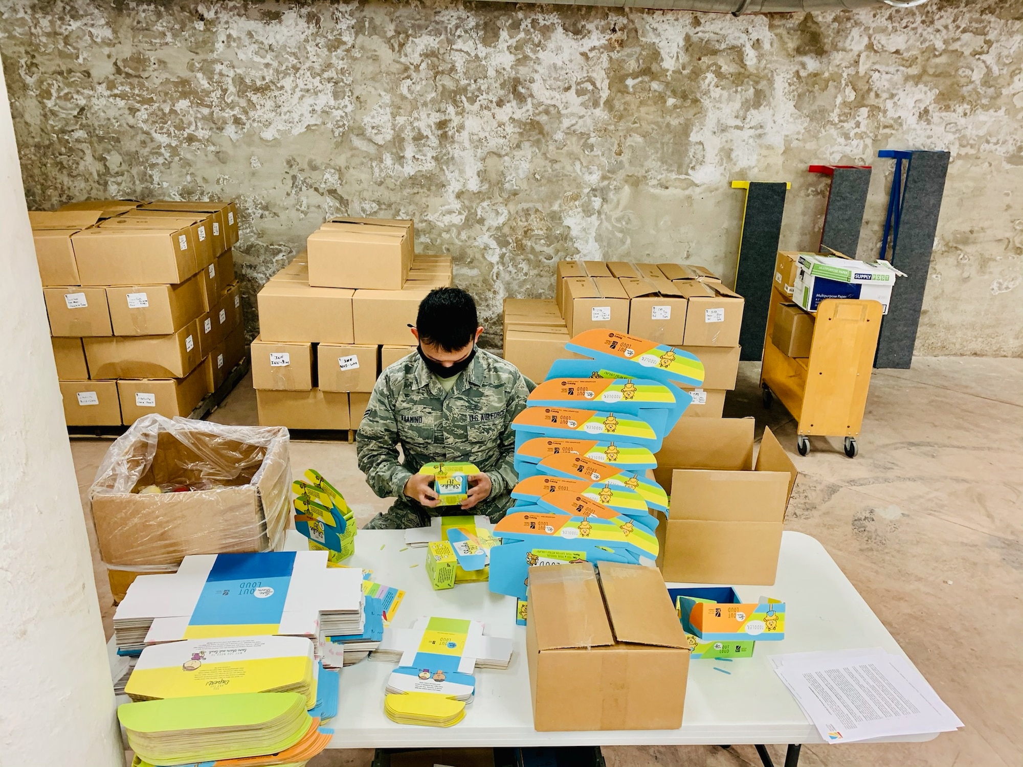 Airman 1st Class Jasper Kaamino of Wright-Patterson Air Force Base’s National Air and Space Intelligence Center assembles “Love Them Out Loud” kits during the Dec. 18 volunteer event benefiting the Dayton Metro Library and early childhood literacy.