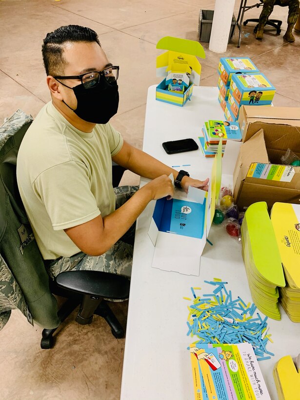 Senior Airman Ariel Guzman of Wright-Patterson Air Force Base’s National Air and Space Intelligence Center assembles “Love Them Out Loud” kits during the Dec. 18 volunteer event benefiting the Dayton Metro Library and early childhood literacy.