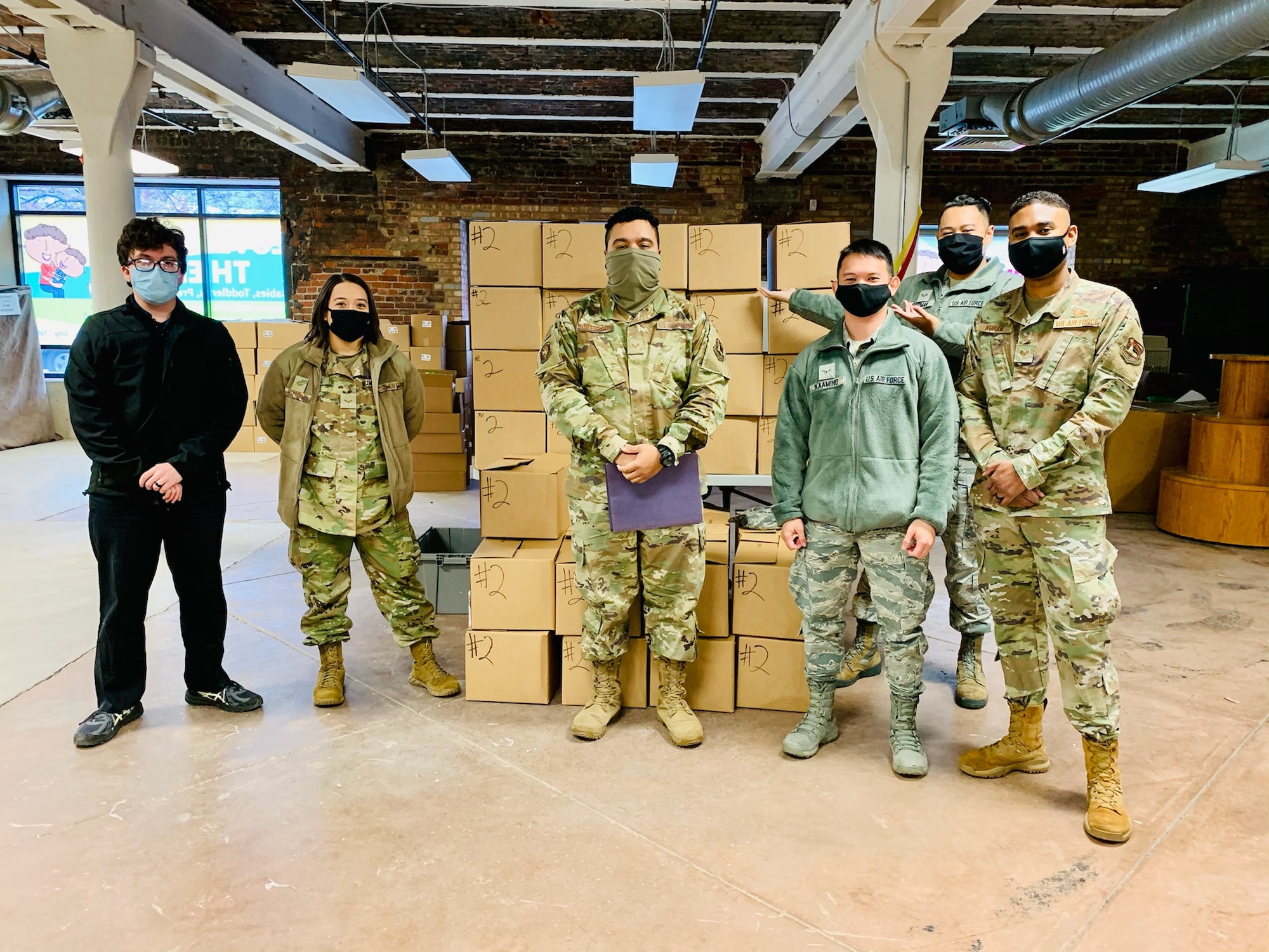 From left: Diego Quevedo, Airman 1st Class Miranda Hutton, Senior Airman Kwame Robertson, Airman 1st Class Jasper Kaamino, Senior Airman Ariel Guzman and Staff Sgt. Randolph Koram put together more than 400 “Love Them Out Loud” kits during the Dec. 18 volunteer event benefiting the Dayton Metro Library and early childhood literacy.