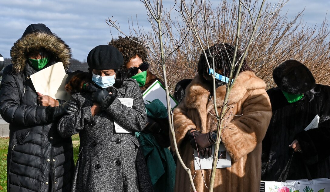 Loved ones of Virginia Carson embrace during a tree dedication ceremony Dec. 17, 2020 at the Air Mobility Command museum at Dover Air Force Base, Delaware. The ceremony celebrated the life of Carson, a prominent Delaware educator who passed away Sept. 3, 2019. Carson’s husband, Charles Carson, was a civilian mortician at the Dover Port Mortuary with the Department of the Air Force for 26 years. (U.S. Air Force photo by Airman Cydney Lee)