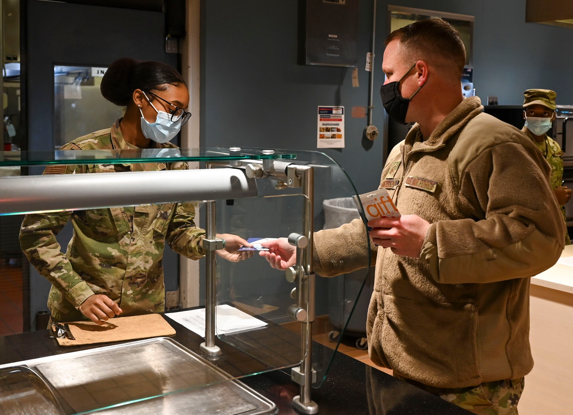 Master Sgt. Christopher Anderson, 436th Communication Squadron first sergeant, hands Airman 1st Class Amira  Allen, 436th Force Support Squadron food service apprentice, a gift card Dec. 18, 2020, at Dover Air Force Base, Delaware. On Dec. 11 and 18, the First Sergeant Council handed out $1,000 worth of gift cards to randomly selected Airmen. The giveaway was part of Operation Warm Heart, a nonprofit organization dedicated to providing financial relief, morale building, and quality of life enhancements to Airmen on Dover AFB. The gift cards were purchased using a $5,000 donation from the Korean War Veterans and Korean Service Veterans Association, Chapter 1, Sussex County, Delaware. (U.S. Air Force photo by Airman 1st Class Cydney Lee)