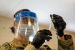 A soldier wearing a mask holds the COVID-19 vaccine.