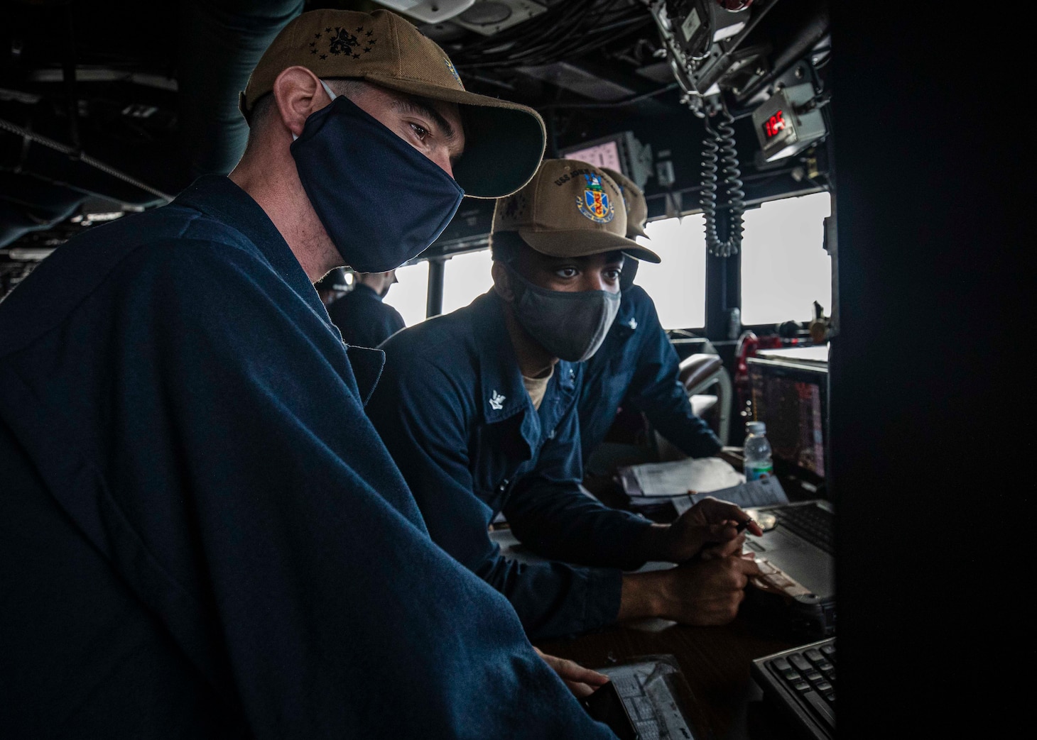 SOUTH CHINA SEA (Dec. 22, 2020) Navigator Lt. j.g. Daniel Feeney, left, from Old Greenwich, Connecticut, and Quartermaster 2nd Class Asah Favors, from Suffolk, Virginia, review the ship’s course on the voyage management system (VMS) while standing watch in the pilot house as the guided-missile destroyer USS John S. McCain (DDG 56) conducts routine underway operations. McCain is forward-deployed to the U.S. 7th Fleet area of operations in support of security and stability in the Indo-Pacific region. (U.S. Navy photo by Mass Communication Specialist 2nd Class Markus Castaneda)