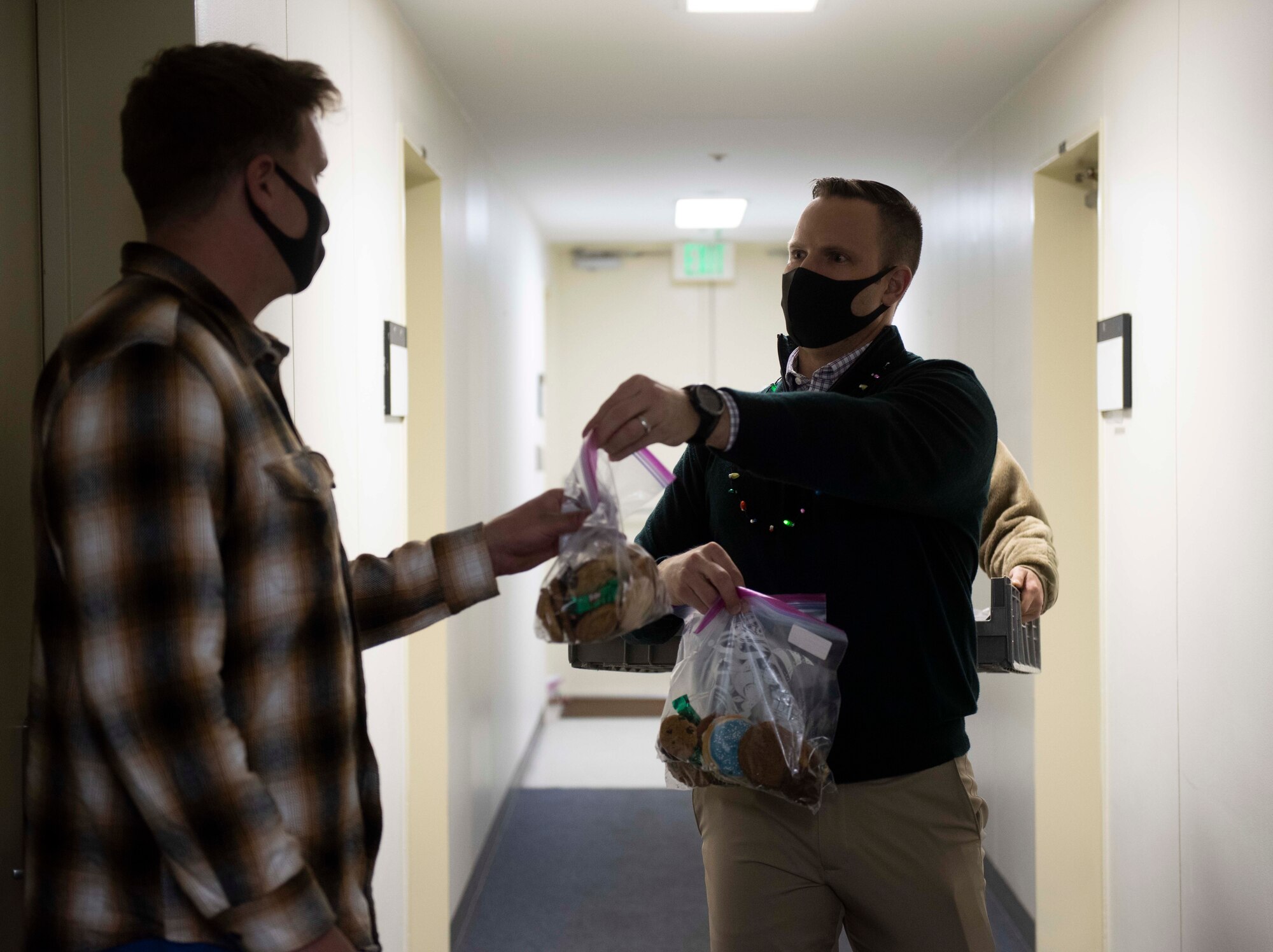 Lt. Col. Stephen Maddox, 374th Communications Squadron commander, drops off a bag of cookies to an Airman during the 2020 Team Yokota Cookie Crunch event on Yokota Air Base, Japan, Dec. 18, 2020. More than 15,600 cookies were donated, bagged and distributed to single U.S. and Japan Air Self-Defense Force Airmen during the holiday season. (U.S. Air Force photo by Airman 1st Class Hannah Bean)
