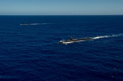 WATERS OFF GUAM (Dec. 11, 2020) The Los Angeles-class fast-attack submarine USS Asheville (SSN 758), right, and the French Navy Rubis-class nuclear powered submarine (SSN) Émeraude steam in formation off the coast of Guam during a photo exercise. Asheville and Émeraude practiced high-end maritime skills in a multitude of disciplines designed to enhance interoperability between maritime forces. Asheville is one of four forward-deployed submarines assigned to Commander, Submarine Squadron 15. (U.S. Navy photo by Mass Communication Specialist 2nd Class Kelsey J. Hockenberger)