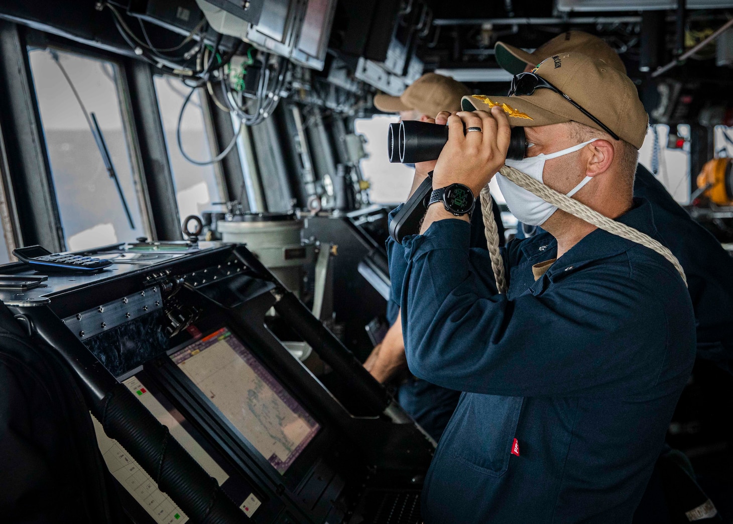 SOUTH CHINA SEA (Dec. 22, 2020) Cmdr. Ryan T. Easterday, commanding officer of the guided-missile destroyer USS John S. McCain (DDG 56) scans the horizon from the pilot house as the ship conducts routine underway operations. McCain is forward-deployed to the U.S. 7th Fleet area of operations in support of security and stability in the Indo-Pacific region. (U.S. Navy photo by Mass Communication Specialist 2nd Class Markus Castaneda)