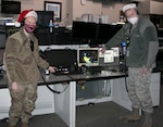 New York Air National Guard Airman 1st Class Megan Mills, left, and Tech. Sgt. Kriston Brown participate in a Santa tracking exercise at the Eastern Air Defense Sector on Dec. 16, 2020. Mills and Brown were prepping for Christmas Eve, when EADS will support the North American Aerospace Defense Command's (NORAD) Santa tracking operation. Tracking operations start at 4 a.m. EST on Dec. 24 on the www.noradsanta.org website. At 6 a.m. EST, children and parents can call toll-free to inquire about Santa at 1-877-Hi-NORAD (1-877-446-6723).