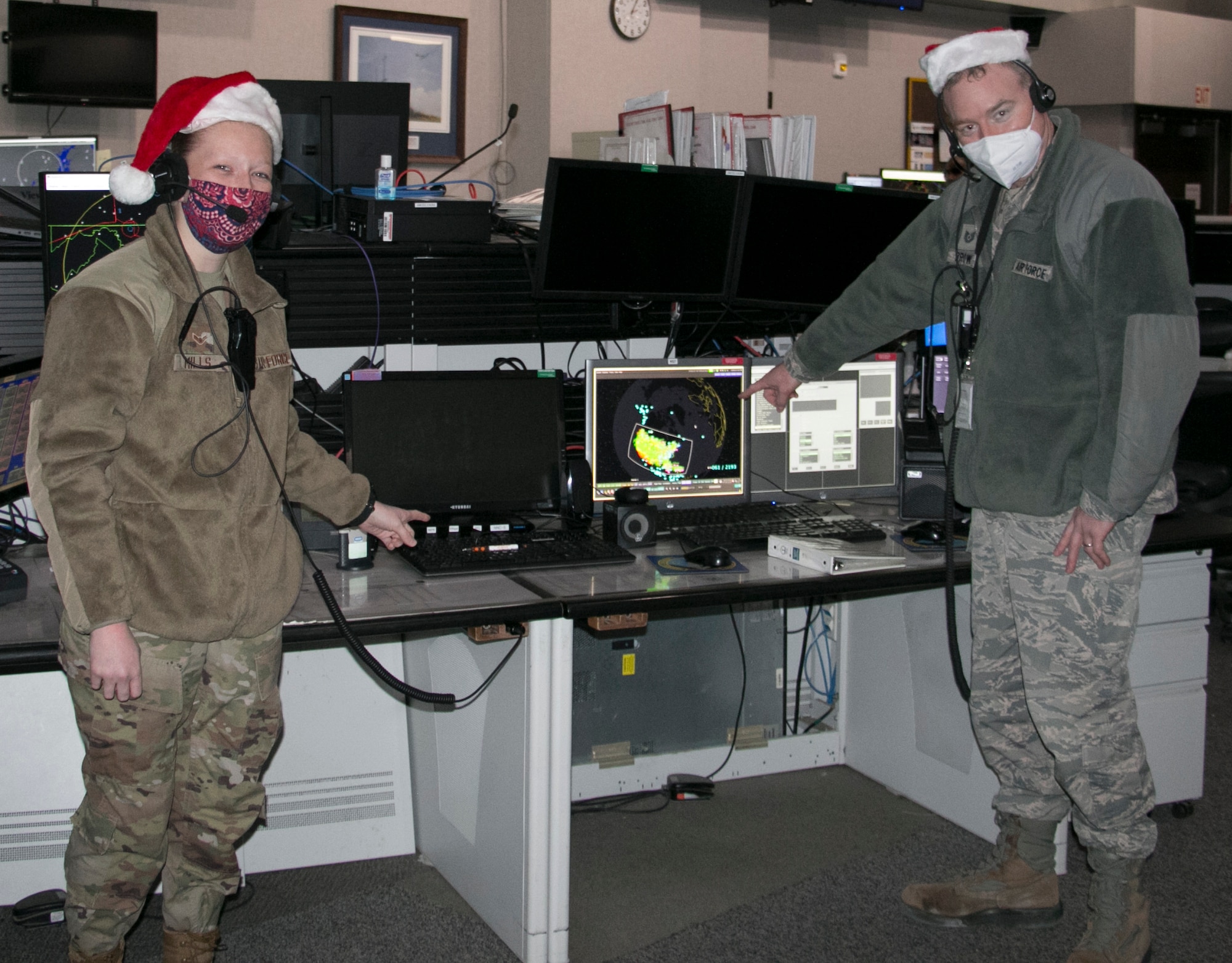 U.S. Air Force Airmen, Airman 1st Class Megan Mills, left, and Tech. Sgt. Kriston Brown, right, participate in a Santa tracking exercise at the Eastern Air Defense Sector on Dec. 16, 2020. Mills and Brown were prepping for Christmas Eve, when EADS will support the North American Aerospace Defense Command's (NORAD) Santa tracking operation. ( U.S. Air National Guard Photo by Tim Jones)