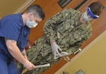 Lt. Cmdr. Alexandra Perry, a physician who works in the intensive care unit at Naval Hospital Jacksonville, reviews a COVID-19 vaccine information sheet prior to receiving the hospital’s first dose of the new vaccine on Dec. 16.