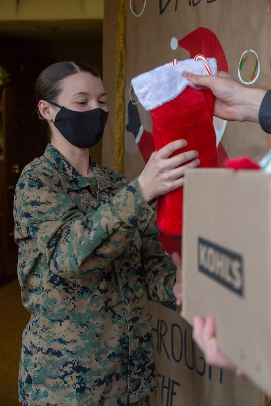 U.S. Marine Corps Cpl. Taylor Borey, a financial management resource analyst with Headquarters and Service Battalion, U.S. Marine Corps Forces Command, Fleet Marine Force Atlantic, receives a stocking Dec. 21, 2020, on Camp Elmore, Norfolk, Virginia. The Marines on Camp Elmore received holiday treats from the Daughters of the American Revolution association and from the families of service members. (U.S. Marine Corps photo by Cpl. Danielle Abshire/released)