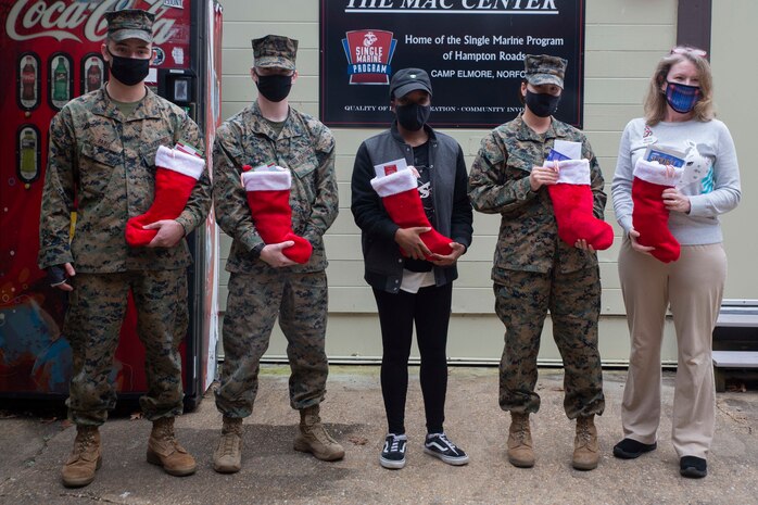 Heather Balow, a representative from the Daughters of the American Revolution (DAR), poses for a photo with Marines from U.S. Marine Corps Forces Command on Camp Elmore, in Norfolk, Virginia, Dec. 21, 2020. The Daughters of the American Revolution is an organization with more than one million members, dedicated to making a difference in their communities, across the country, and the world. Members of the local DAR chapter collected gifts for the Marines and Sailors of U.S. Marine Corps Forces Command. (U.S. Marine Corps photo by Sgt. Desmond Martin/released)