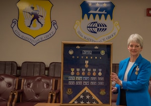 Erma Asaro, an administrative executive assistant for the 437th Maintenance Group, poses with her shadowbox during her retirement ceremony, at Joint Base Charleston S.C., Dec. 18, 2020. Asaro served 51 years of outstanding service and was instrumental in the success of numerous large formation exercises, humanitarian relief operations and real world contingencies.