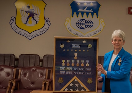 Erma Asaro, an administrative executive assistant for the 437th Maintenance Group, poses with her shadowbox during her retirement ceremony, at Joint Base Charleston S.C., Dec. 18, 2020. Asaro served 51 years of outstanding service and was instrumental in the success of numerous large formation exercises, humanitarian relief operations and real world contingencies.