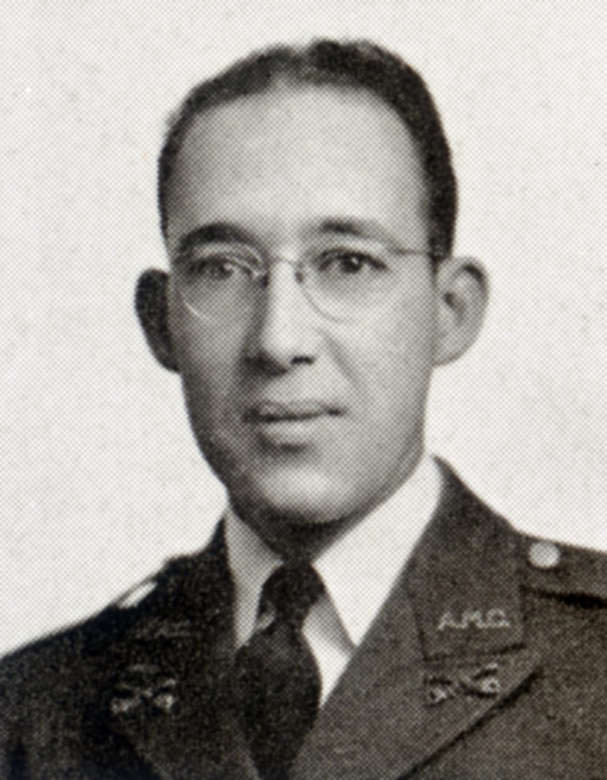 A man in glasses and a uniform looks at the camera.