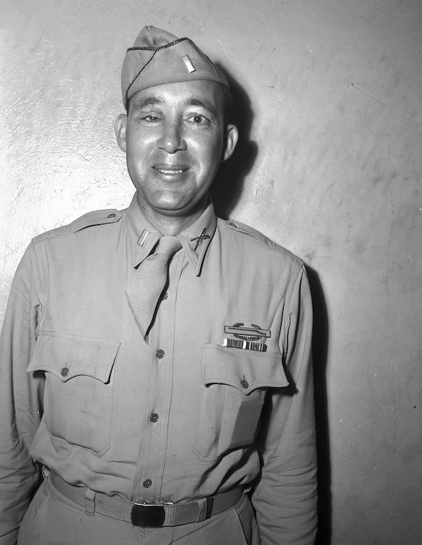 A man in dress uniform and cap smiles for the camera.