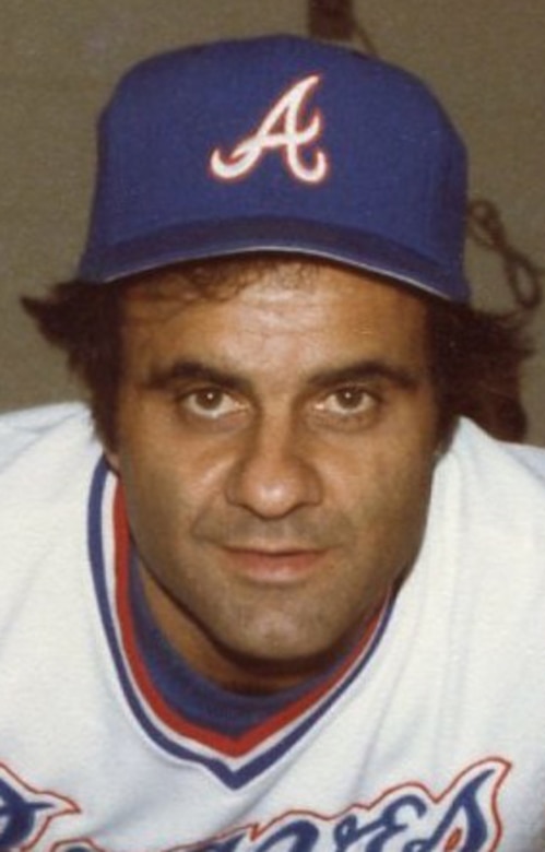 A man in a baseball cap and shirt poses for a photo.