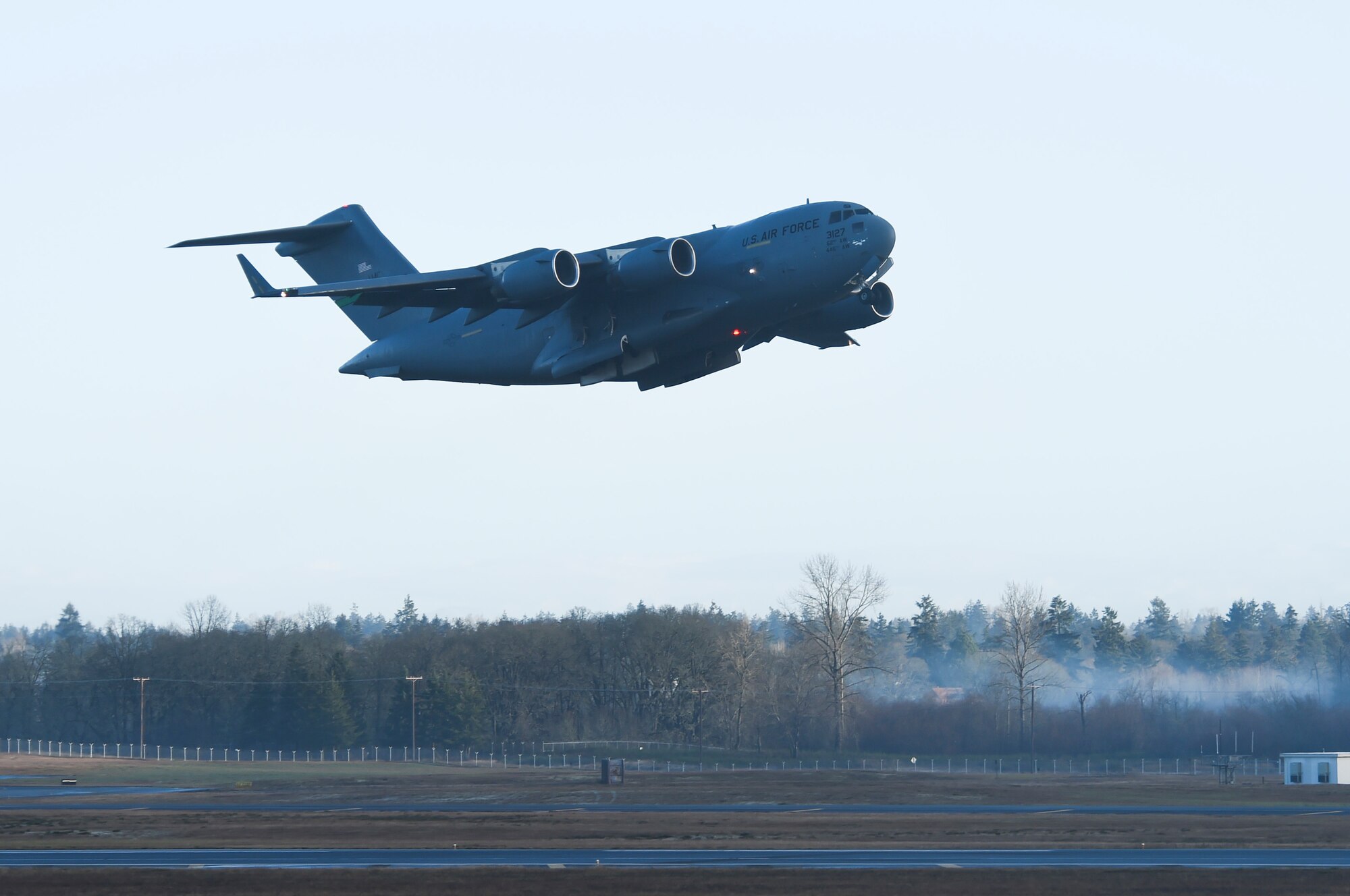 A 62nd Airlift Wing C-17 Globemaster III takes off from Joint Base Lewis-McChord, Wash., Dec. 22, 2020, following the construction of a new concrete arch bridge under the runway. The Seattle District Corps of Engineer led the construction effort, which reopened the runway’s full 10,000-foot operational length. (U.S. Air Force photo by Master Sgt. Julius Delos Reyes)