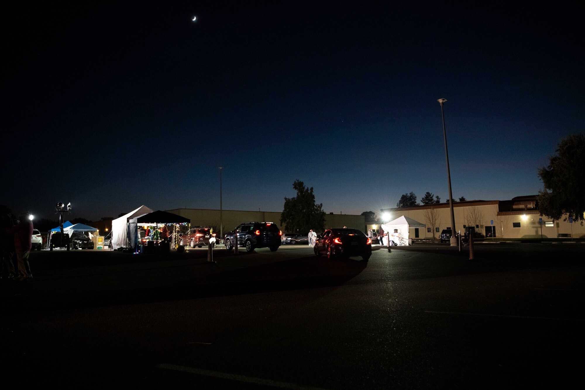 Cars line up at the Candy Cane Lane drive-thru Dec. 18, 2020, at Travis Air Force Base, California. During the event, volunteers distributed 260 gift bags to Airmen and their families. (U.S. Air Force photo by Airman 1st Class Alexander Merchak)