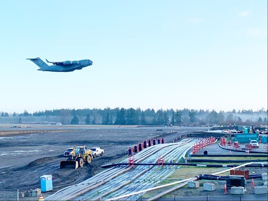 A McChord C-17 Globemaster III flies over the newly constructed airfield bridge to reopen the full runway at McChord Field at about 10 a.m. Dec. 22. (Photo Credit: Joe Piek, JBLM Public Affairs)