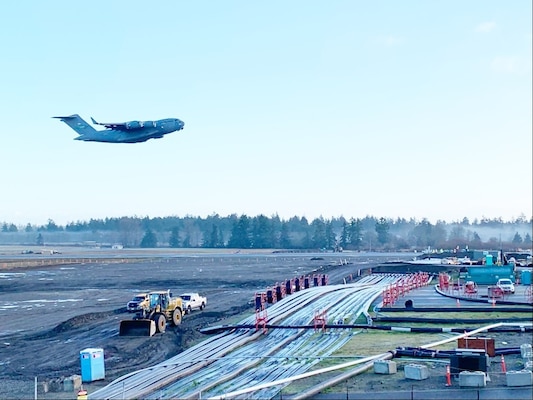A McChord C-17 Globemaster III flies over the newly constructed airfield bridge to reopen the full runway at McChord Field at about 10 a.m. Dec. 22. (Photo Credit: Joe Piek, JBLM Public Affairs)