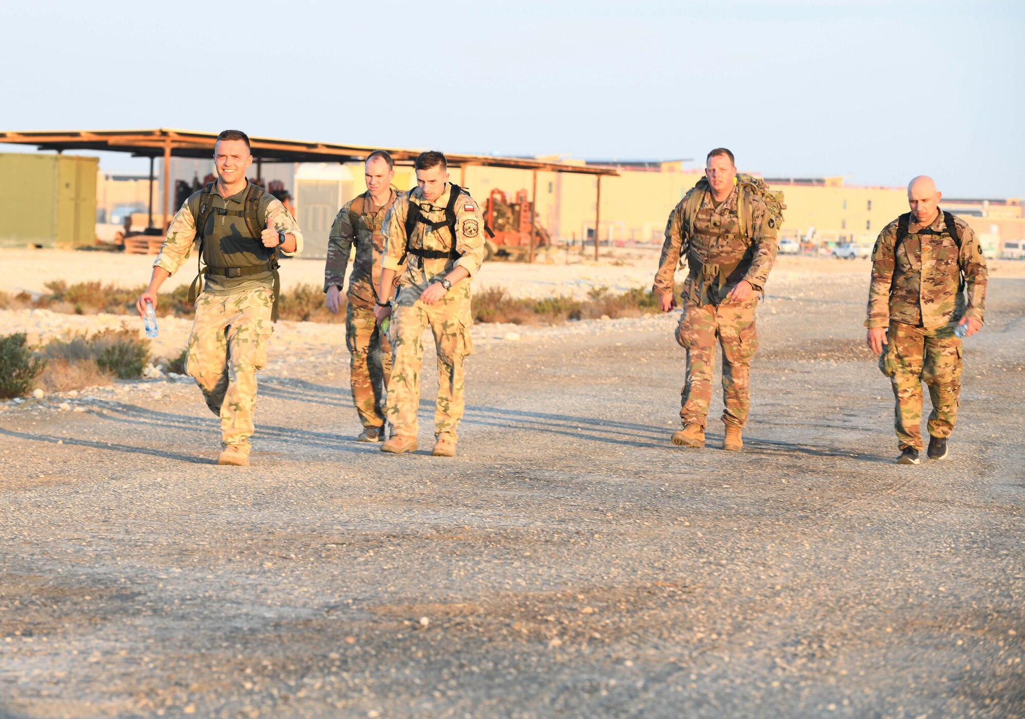 U.S. and coalition military members ruck together during the traditional 30-kilometer (18.6-mile) Norwegian foot march event. The tradition began in 1915, 10 years after Norway gained its independence from Sweden and has become a rite of passage for all Norwegian military members. They joined nearly 120 other coalition members, including Americans, Australians, New Zealanders, British and Canadians who participated in the march under the supervision of Norwegian armed forces Capt. Magne Rambo, deployed to Al Udeid AB as part of the U.S. Central Command Partner Integration Enterprise. (U.S. Air Force photo by Staff Sgt. Kayla White)