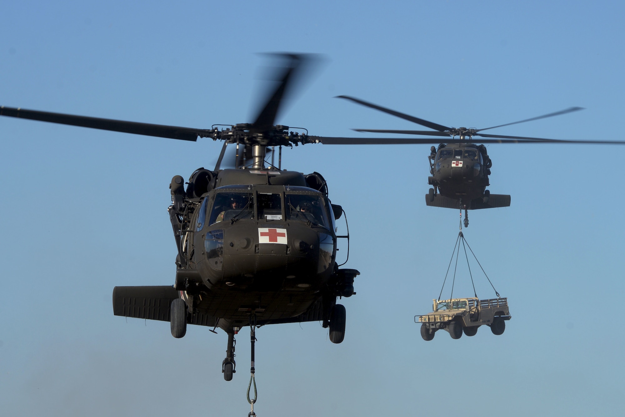 Two UH-60 Black Hawk helicopters carry sling loaded cargo to predetermined destinations during Operation Nightstorm Dec. 15, 2020, at Joint Base San Antonio-Chapman Training Annex, Texas. (U.S. Air Force photo by Tech. Sgt. Samantha Mathison)