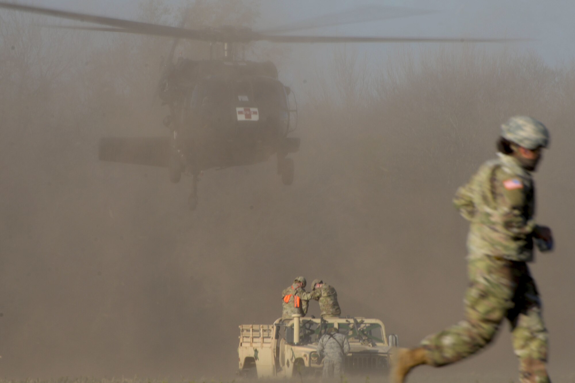 A UH-60 Black Hawk helicopter hovers over ground crew team members in preparation for sling loading a high mobility multi-purpose wheeled vehicle Dec. 15, 2020, at Joint Base San Antonio-Chapman Training Annex, Texas. (U.S. Air Force photo by Tech. Sgt. Samantha Mathison)