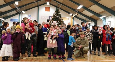 Members from Thule Air Base bring Christmas gifts to local Greenlandic children.