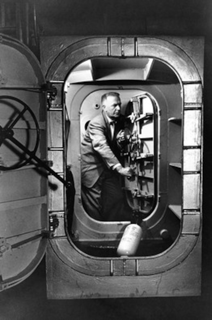 Dr. Hubertus Strughold, the first director of the U.S. Air Force School of Aviation Medicine’s Department of Space Medicine, examines the interior of a low pressure chamber that was converted into the world’s first space cabin simulator.