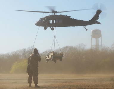 Col. Kjäll Gopaul, Air Education and Training command pathfinder, watchs as a high mobility multi-purpose wheeled vehicled is lifted off the ground by a UH-60 Black Hawk helicopter Dec. 15, 2020, at Joint Base San Antonio-Chapman Training Annex, Texas. (U.S. Air Force photo by Tech. Sgt. Samantha Mathison)