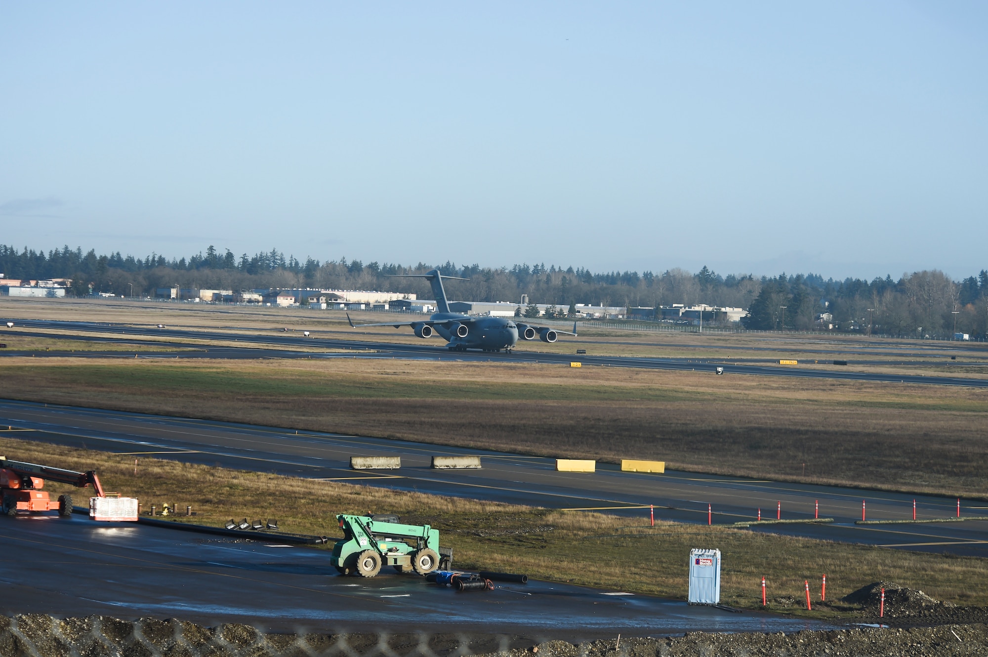 A 62nd Airlift Wing C-17 Globemaster III lands at Joint Base Lewis-McChord, Wash., Dec. 22, 2020, following the construction of a new concrete arch bridge under the runway. The Seattle District Corps of Engineer led the construction effort, which reopened the runway’s full 10,000-foot operational length. (U.S. Air Force photo by Master Sgt. Julius Delos Reyes)