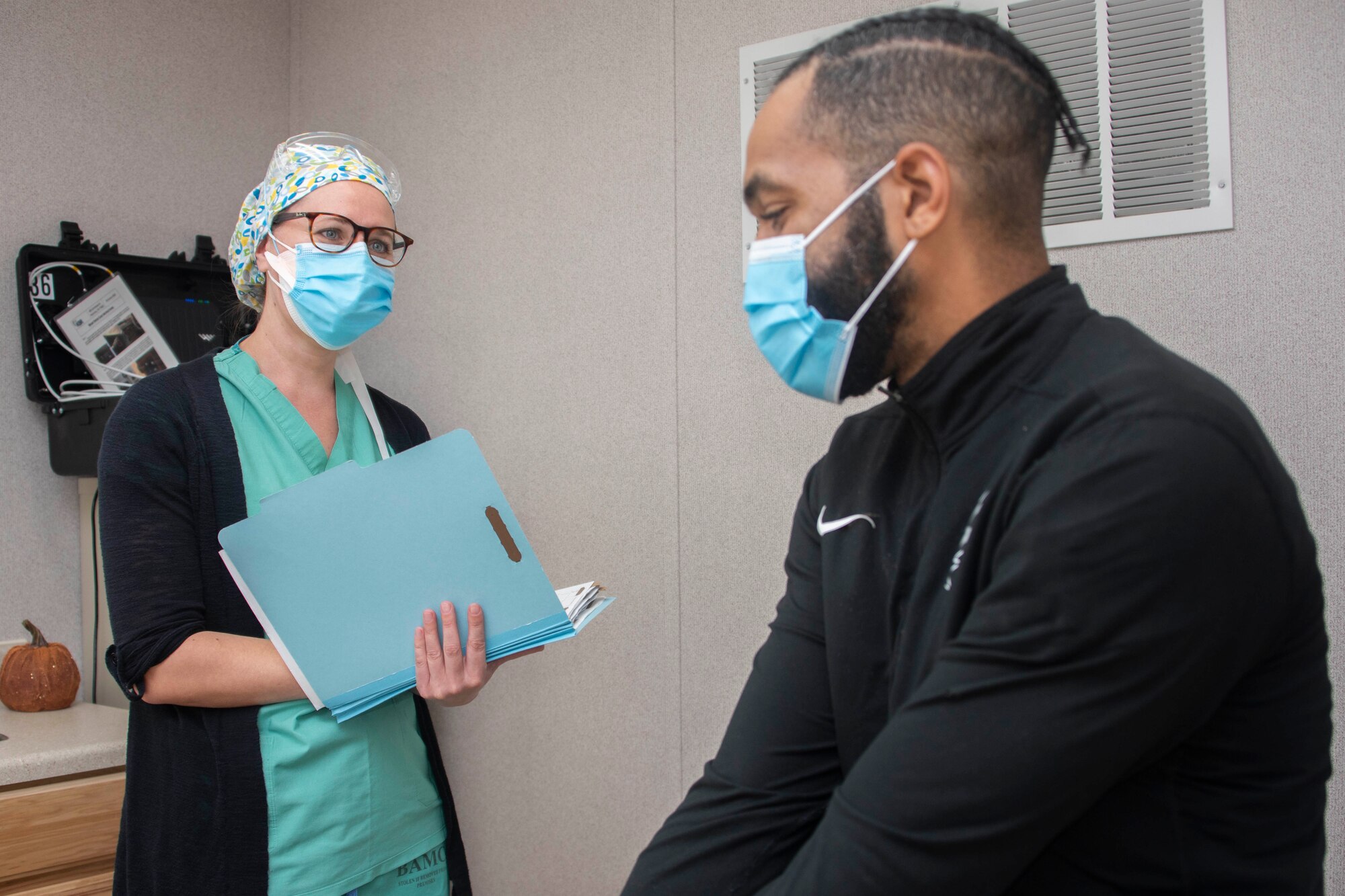 A nurse interacts with an assistant.