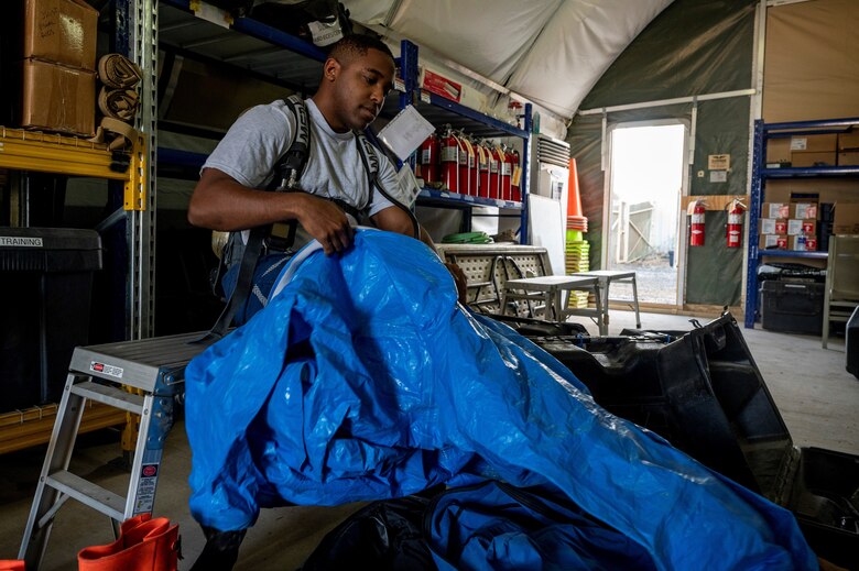 U.S. Air Force Staff Sgt. Jude Stueckle, 380th Expeditionary Civil Engineer Squadron (ECES) emergency management (EM) flight logistics technician, puts on a hazardous material (HAZMAT) uniform during a HAZMAT exercise at Al Dhafra Air Base, United Arab Emirates, Dec. 18, 2020.
