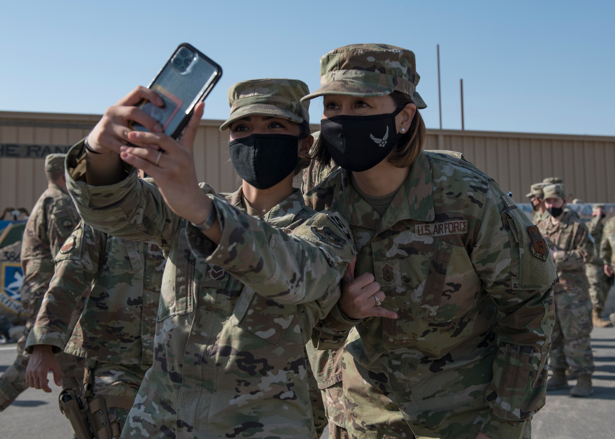A U.S. Air Force Airman assigned to the 386th Expeditionary Security Forces Squadron takes a photo with Chief Master Sergeant of the Air Force JoAnne S. Bass during a visit at Ali Al Salem Air Base, Kuwait, Dec. 22, 2020. Senior leaders took time to thank ASAB Airmen for their service and sacrifice during the holiday season, as the nation cannot compete, deter and win without their dedication. (U.S. Air Force photo by Senior Airman Monica Roybal)