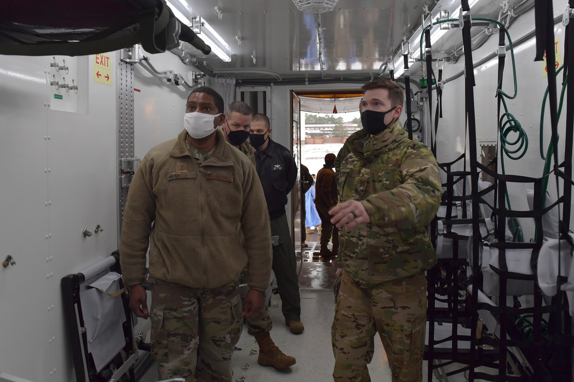 Airmen standing in an isolated containment chamber.