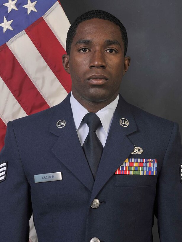 A man wearing dress blues looks at the camera.