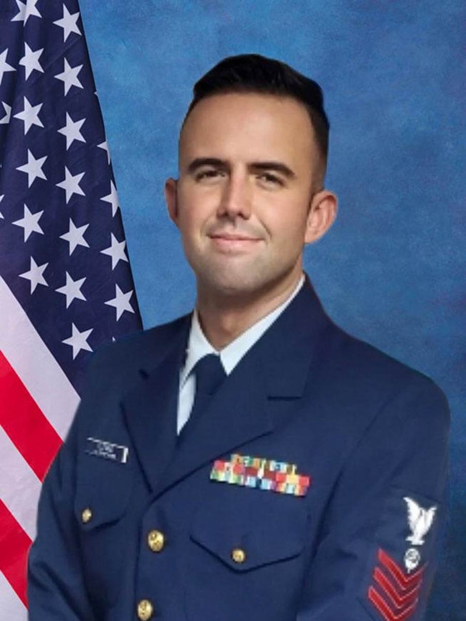 A man in service uniform smiles at the camera.