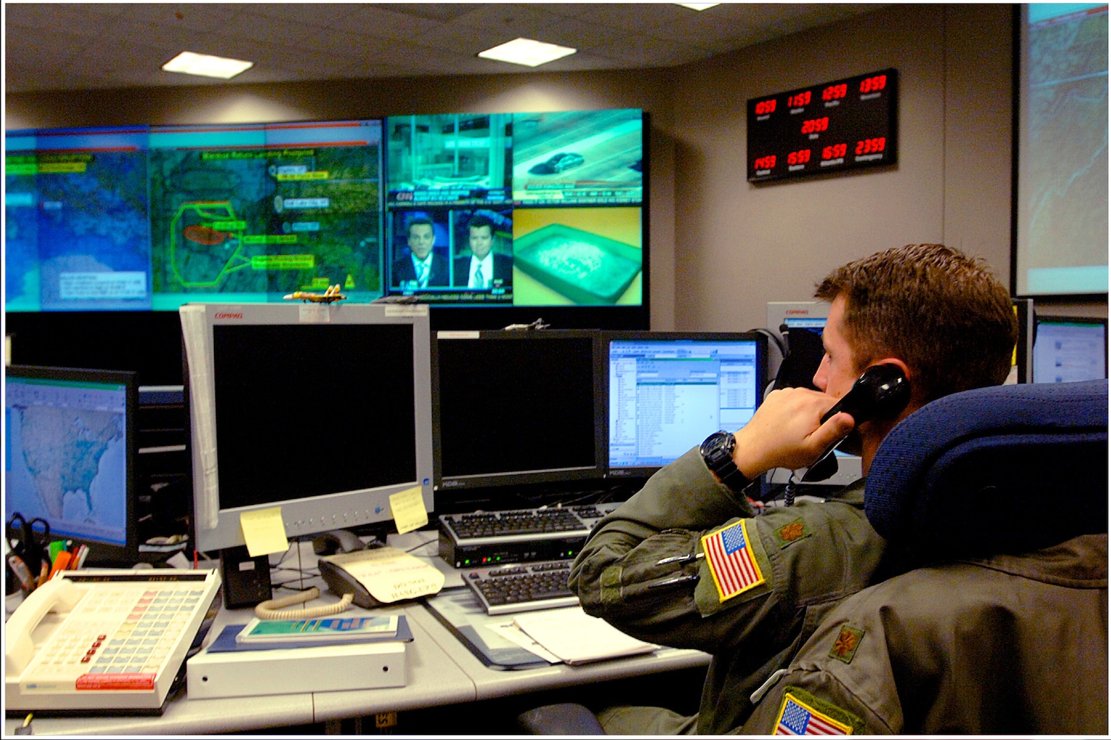 A photo of a North American Aerospace Defense Command and United States Northern Command operator answering the phone while on shift in the NORAD and USNORTHCOM command center.
