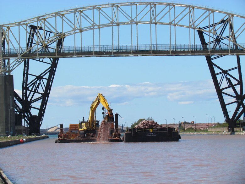 U.S. Army Corps of Engineers contractor, Trade West Construction, deepening the upstream channel for the New Lock at the Soo in Sault Ste. Marie, Michigan. Channel deepening is the first phase of the new lock project and should wrap up fall 2021. The project’s second phase to stabilize the existing upstream approach walls will begin in April 2021. The final phase is construction of the new lock chamber. The Detroit District is preparing the 100% design package and the final design review will be in early 2021. Corps officials anticipate phase three construction will begin in spring 2022.