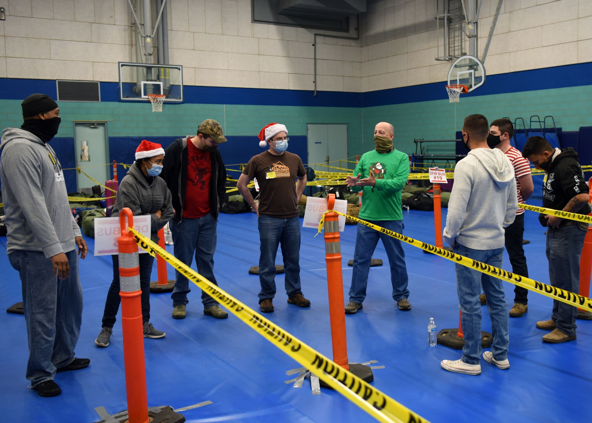 Exodus volunteer JJ Graham, briefs other volunteers about the procedures before the students arrive during Exodus at the Mathis Fitness Center on Goodfellow Air Force Base, Texas, Dec. 22, 2020. Graham and other volunteers stayed at the event until every student was on their way to their destination. (U.S. Air Force photo by Airman 1st Class Ethan Sherwood)