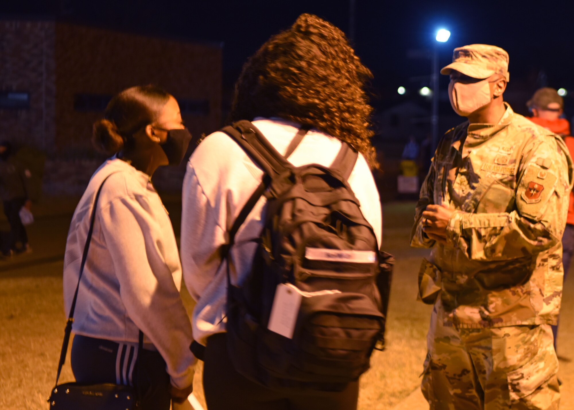U.S. Air Force Col. James Finlayson, 17th Training Wing vice commander, converses with two students before they board their bus during Exodus at the Mathis Fitness Center on Goodfellow Air Force Base, Texas, Dec. 22, 2020. Finlayson and other members of Goodfellow interacted with the students wishing them safe travels and happy holidays. (U.S. Air Force photo by Airman 1st Class Ethan Sherwood)