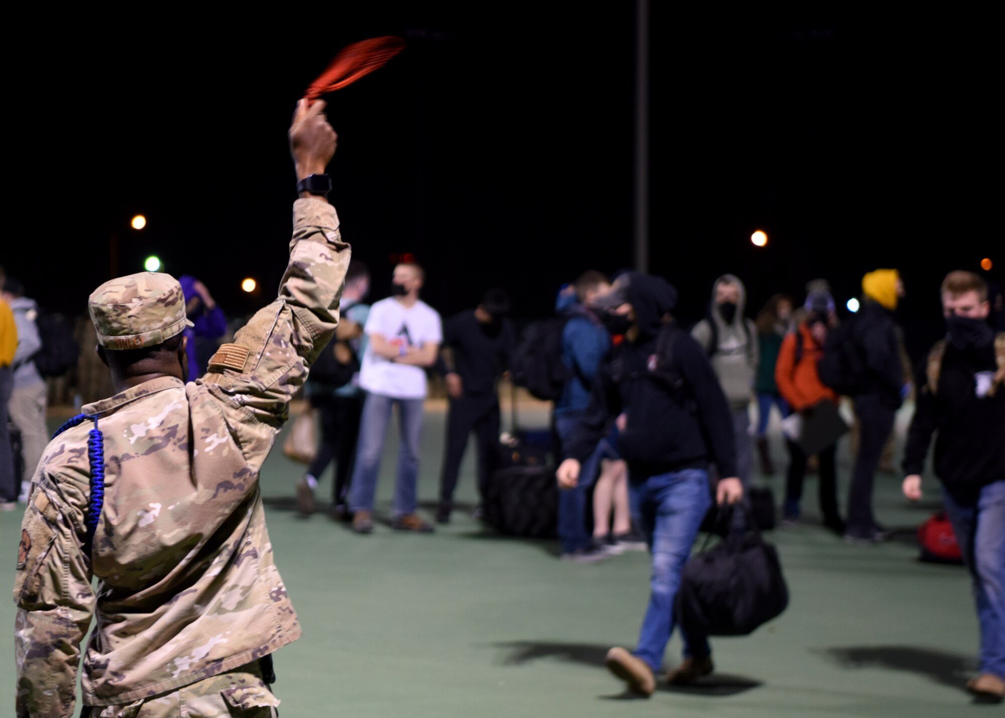 U.S. Air Force Tech. Sgt. Derwin Finley, 312th Training Squadron master military training leader, signals his group to load up on the bus during Exodus at the Mathis Fitness Center on Goodfellow Air Force Base, Texas, Dec. 22, 2020. Finley and other MTLs escorted students to their busses to ensure they safely made it to their destinations. (U.S. Air Force photo by Airman 1st Class Ethan Sherwood)
