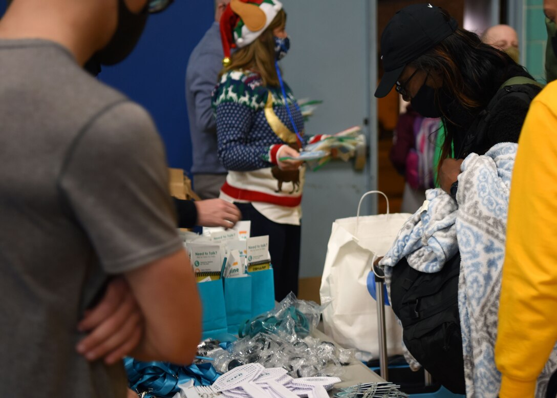 A student chooses from a pile of gifts provided by base organizations during Exodus at the Mathis Fitness Center on Goodfellow Air Force Base, Texas, Dec. 22, 2020. Students were given resources, prizes, and goodies before boarding their busses. (U.S. Air Force photo by Airman 1st Class Ethan Sherwood)