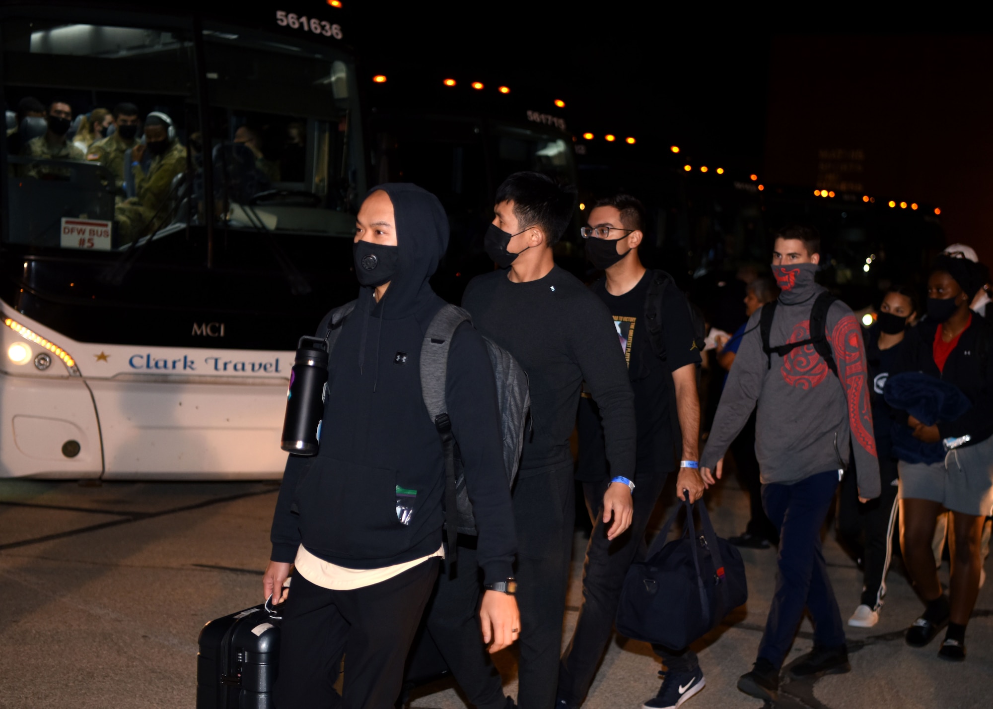 Students carry their bags to busses during Exodus at the Mathis Fitness Center on Goodfellow Air Force Base, Texas, Dec. 22, 2020. Students were grouped by location and boarded quickly to take their flights. (U.S. Air Force photo by Airman 1st Class Ethan Sherwood)