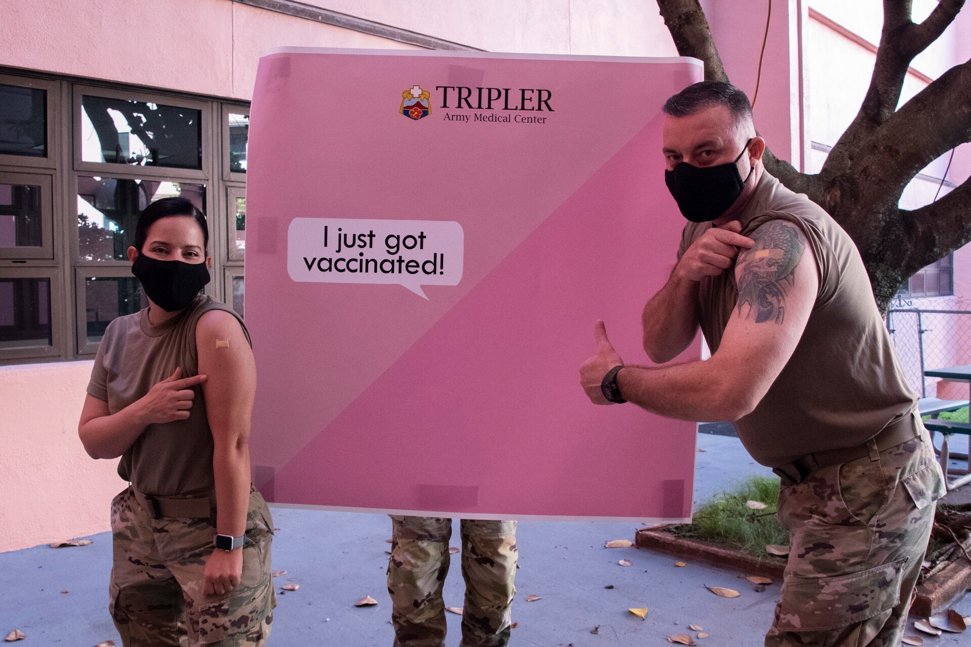 Col. Elba Villacorta, commander of Public Health Command-Pacific, and Sergeant Maj. Danny Hailey, sergeant major of PHC-P, stand in front of a poster after receiving the Pfizer vaccine at Tripler Army Medical Center, Honolulu, on Dec. 23, 2020. The inoculation was part of the Department of Defense COVID-19 vaccine distribution and administration plan that is a phased, standardized and coordinated strategy for prioritizing, distributing, and administering COVID-19 vaccines to protect DoD personnel, maintain readiness, and support the national COVID-19 response. (U.S. Army photo by Amber E. Kurka)