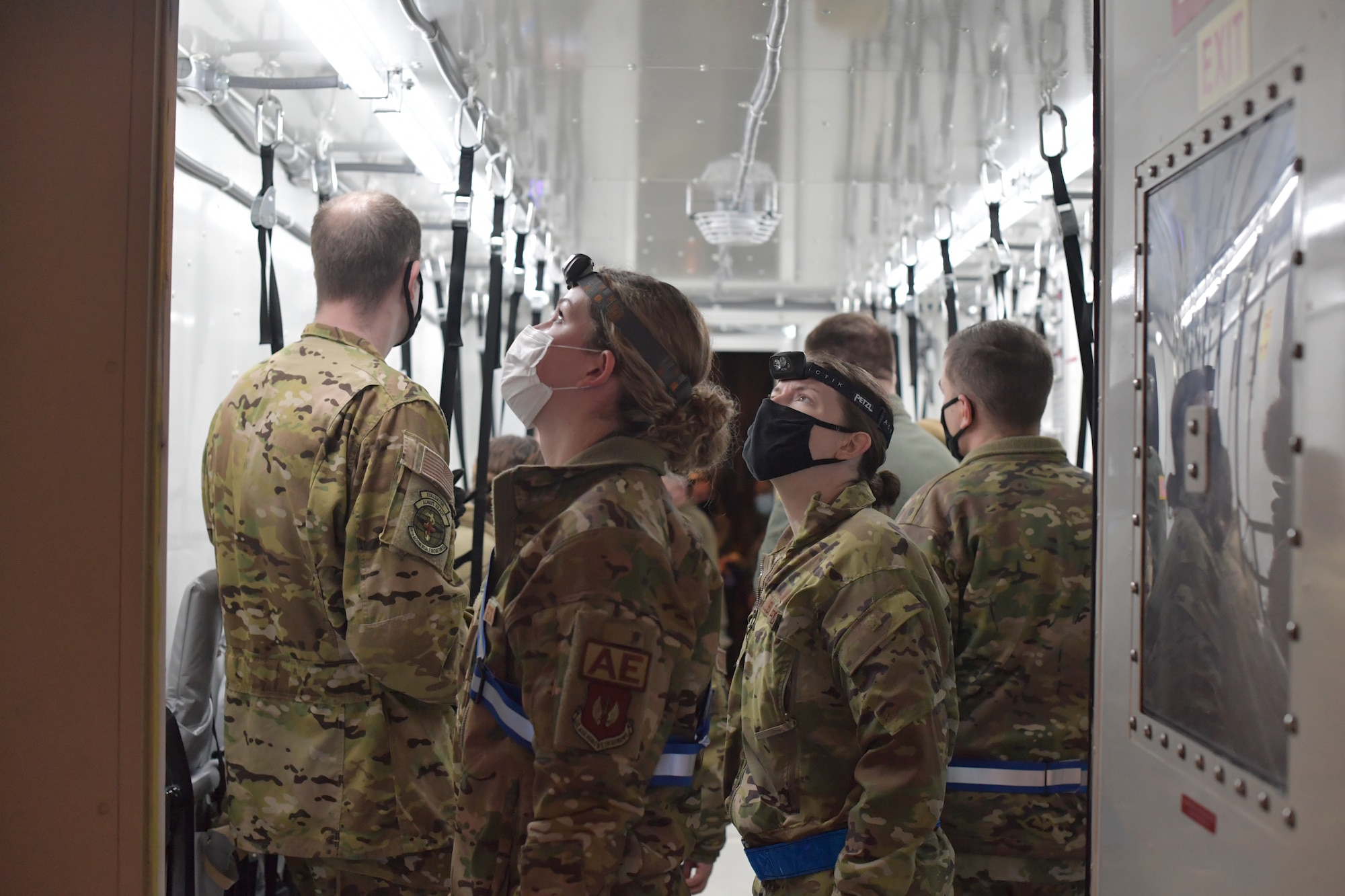 Airmen standing inside an isolated containment chamber.